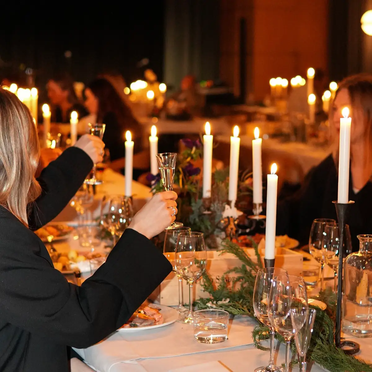 Skål på julbordet hos Ellery Beach House Gäster skålar vid julbord på Ellery Beach House med levande ljus och festlig stämning