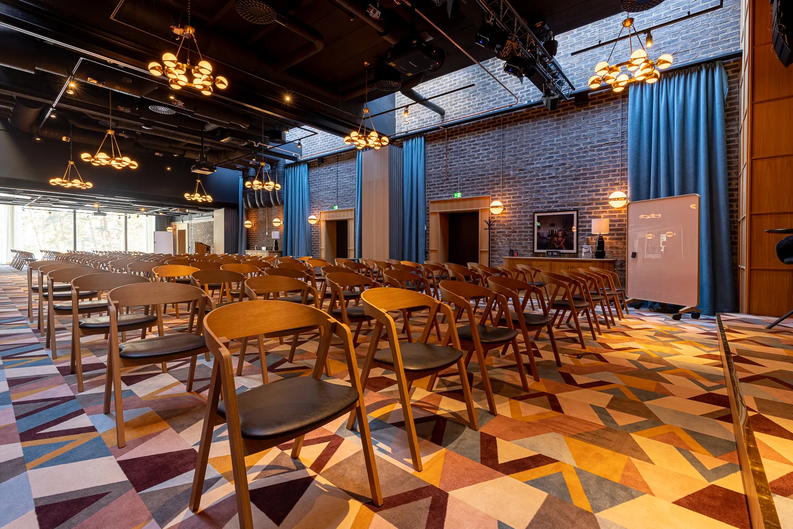 Konferensrum på Ellery Beach House Stort konferensrum på Ellery Beach House med stolsrader, scen och dekorativ belysning.