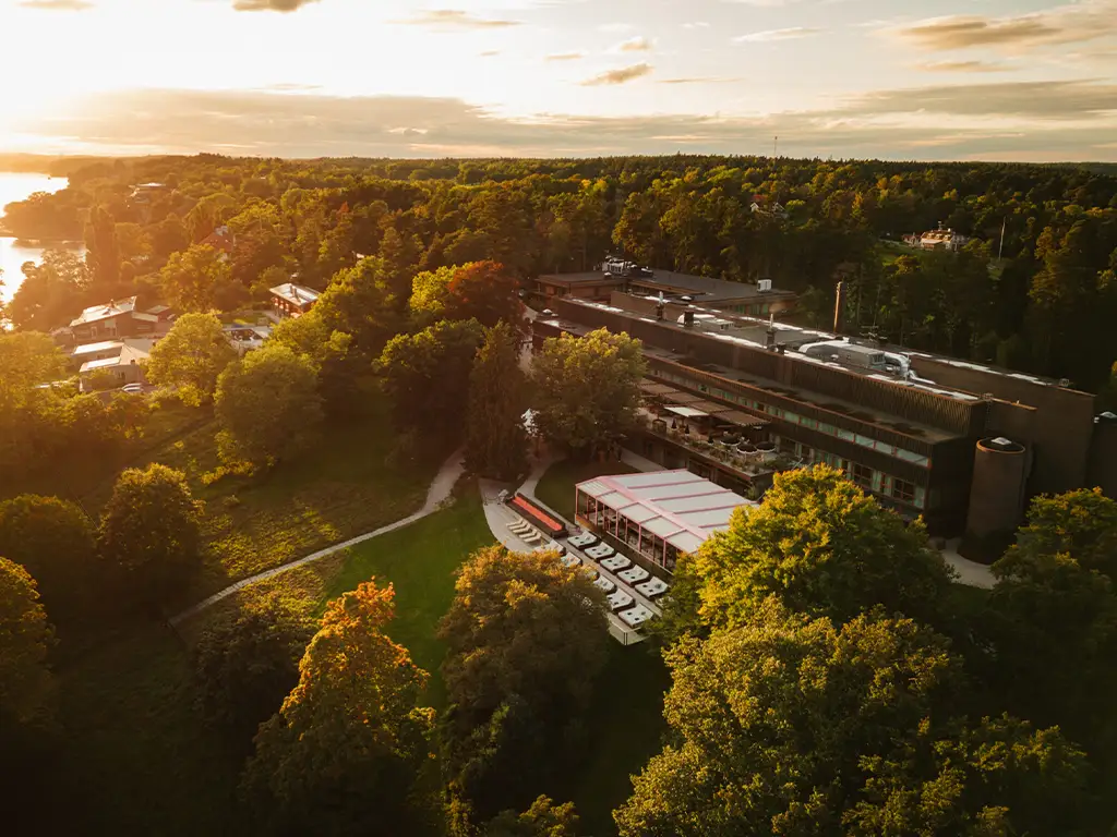 Ellery Beach House från ovan Drönarbild över Ellery Beach House omgivet av grönska i solnedgång.