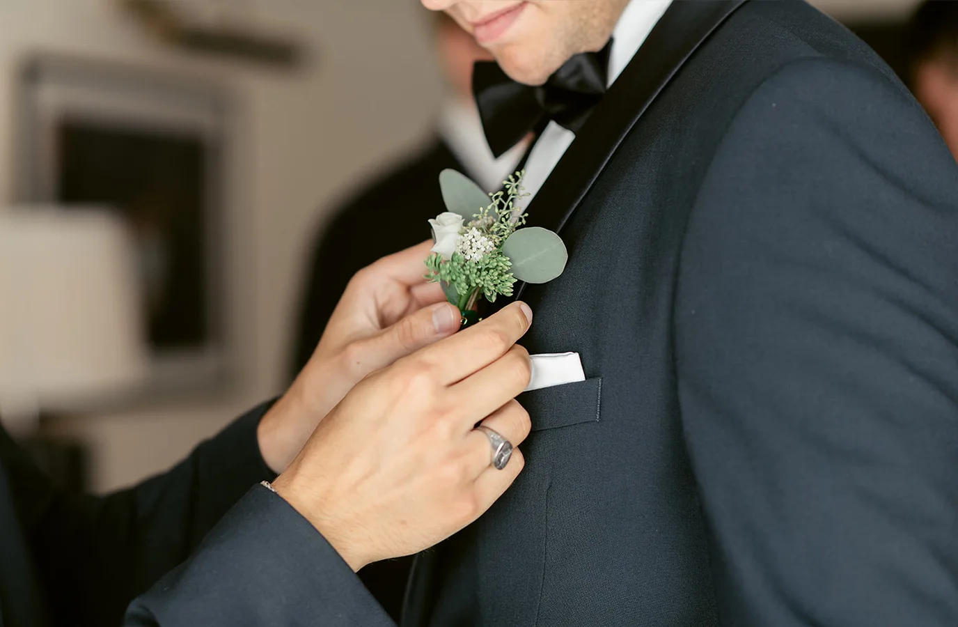 The Final Details Groom having his boutonniere adjusted before the wedding ceremony at Ellery Beach House