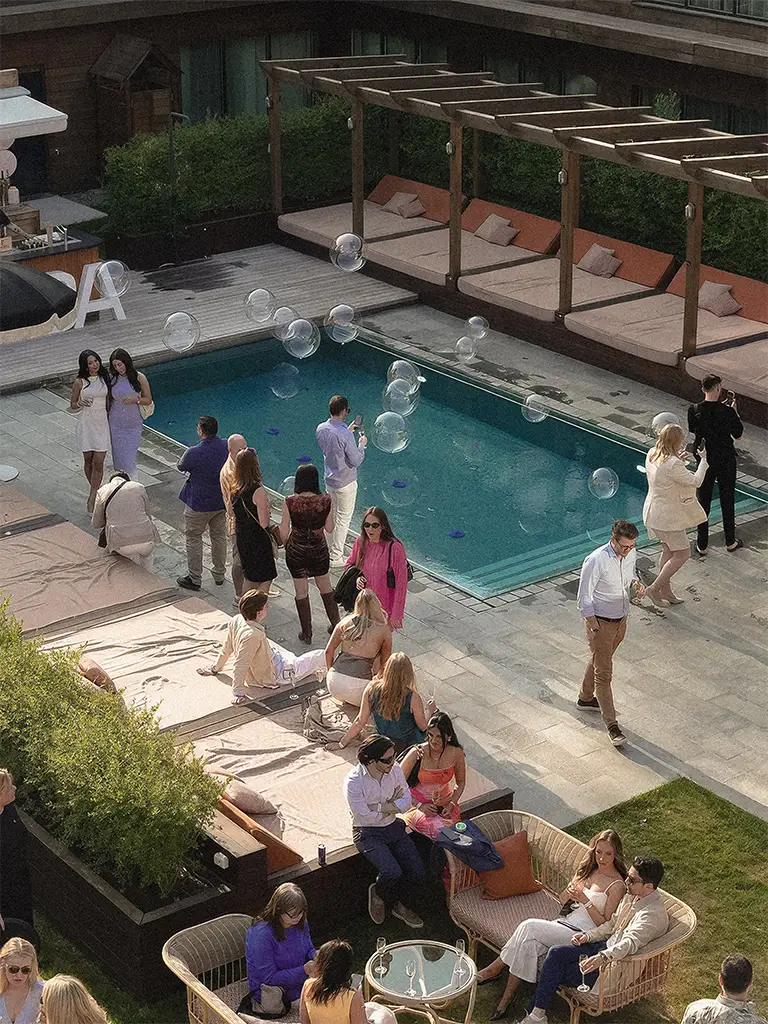 Guests mingling by the pool during an event at Ellery Beach House near Stockholm