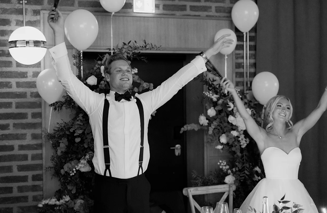 The Celebration Begins Wedding couple celebrating with guests during a wedding dinner at Ellery Beach House